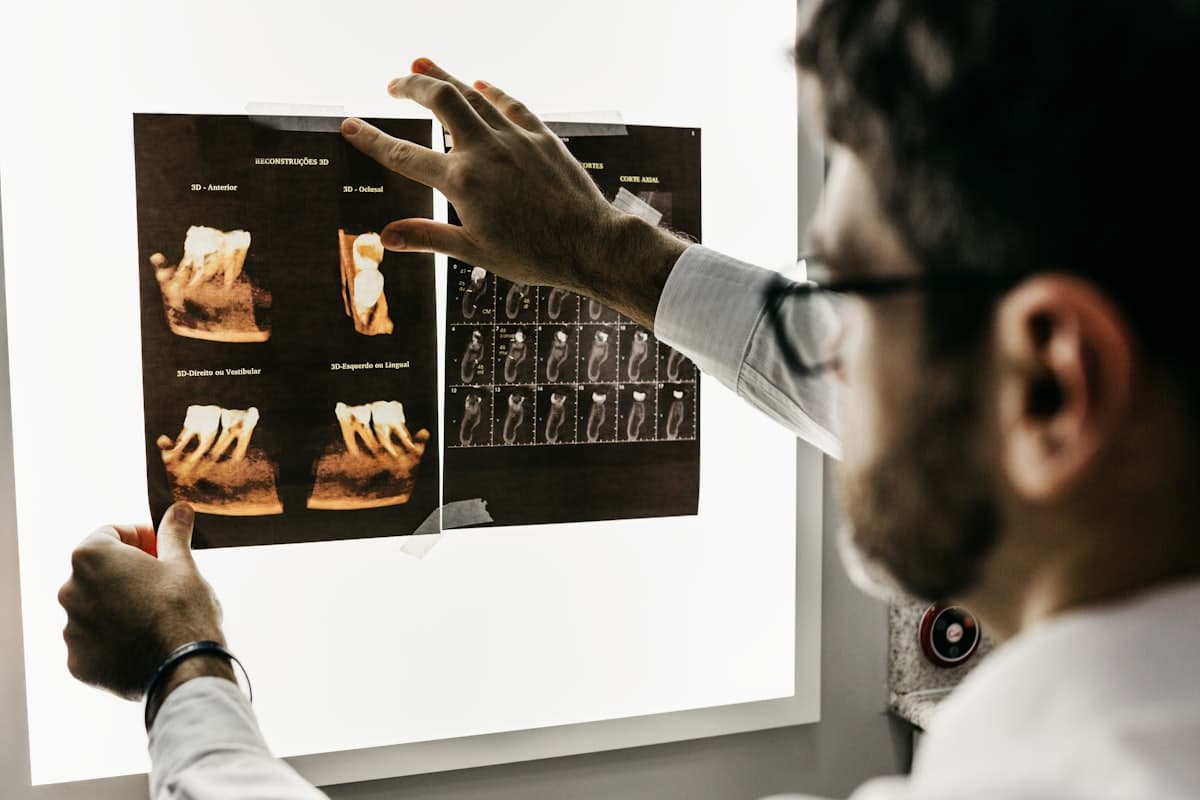 A dentist reviewing patient scans on a lightbox in the practice